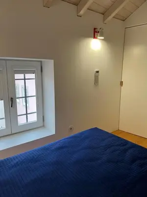 a bedroom with a blue bed and a window at Get bindings and books on duplex in Porto
