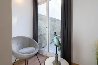 a bird sitting on a window sill next to a chair at Host Wise - Enchanting Unique Flat - Ace Location in Porto