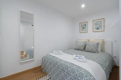 a bedroom with a bed and a mirror at Host Wise - Enchanting Unique Flat - Ace Location in Porto