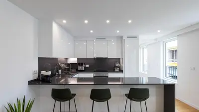 a kitchen with a black counter and green stools at Morro Premium Apartment w Free Parking in Vila Nova de Gaia