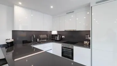 a kitchen with white cabinets and silver appliances at Morro Premium Apartment w Free Parking in Vila Nova de Gaia