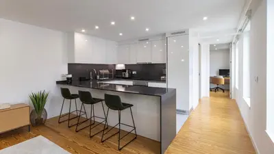 a kitchen with a black counter and stools at Morro Premium Apartment w Free Parking in Vila Nova de Gaia