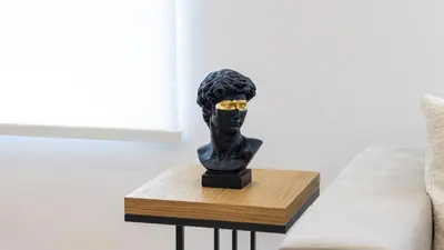 a black bust on a wooden table next to a couch at Morro Premium Apartment w Free Parking in Vila Nova de Gaia