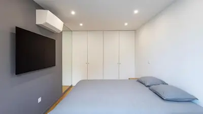a bedroom with a bed and a tv on a wall at Morro Premium Apartment w Free Parking in Vila Nova de Gaia