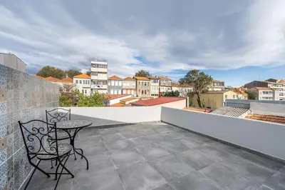 a patio with a table and chairs on a balcony at Charming 2BR w Terrace & Garden in Porto
