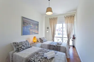 a bedroom with two beds and a window at Host Wise - Sweet Flats - Bolhão City Center in Porto