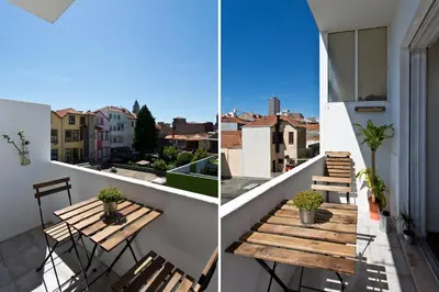 a balcony with a wooden table and chairs at Host Wise - Sweet Flats - Bolhão City Center in Porto
