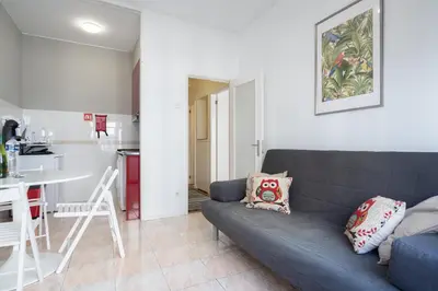 a living room with a blue couch and a kitchen at Host Wise - Sweet Flats - Bolhão City Center in Porto