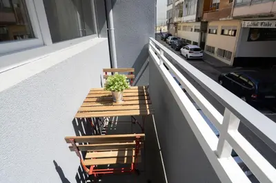 a wooden table and two chairs on a balcony at Host Wise - Sweet Sunny Flat with Balcony in Vila Nova de Gaia