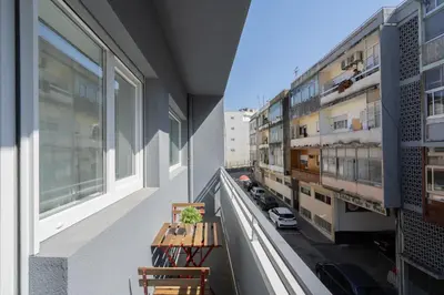 a balcony with two chairs and a table on a building at Host Wise - Sweet Sunny Flat with Balcony in Vila Nova de Gaia