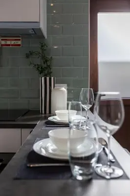 a table with plates and wine glasses on it at Chic Loft with Garden, Sleeps 4 in Porto