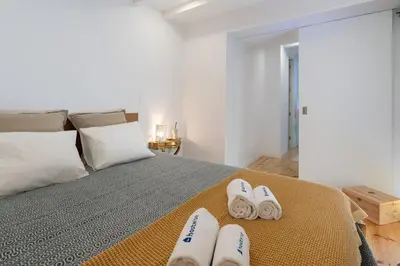 a bedroom with a bed with two pairs of slippers at Host Wise - Sunny Bright Duplexes & Pool in Vila Nova de Gaia