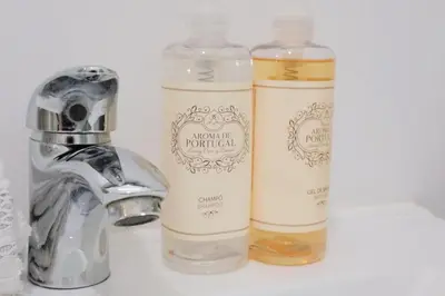 two bottles of soap sitting next to a faucet at Downtown Premiu in center of Porto 3BR with AC in Porto