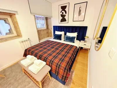 a small bedroom with a bed and a chair at Downtown Premiu in center of Porto 3BR with AC in Porto