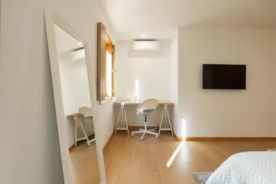a bedroom with a bed and a table and a mirror at Host Wise - Elegant Home in the Heart of Porto in Porto