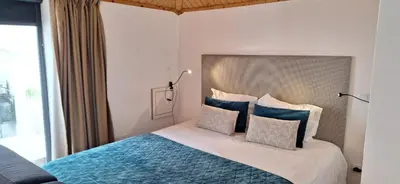 a bedroom with a bed with blue and white pillows at Vila Terra Studio III in Vila Nova de Gaia