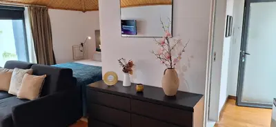 a living room with a couch and a table with vases on it at Vila Terra Studio III in Vila Nova de Gaia