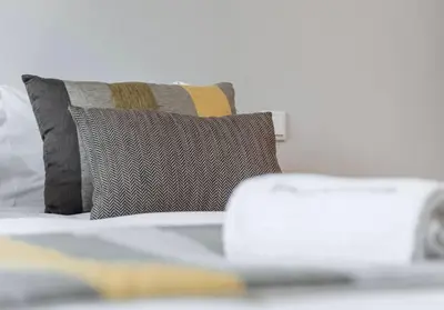 a bed with a pillow and a laptop on it at NEW LUX 2BR Flat Free Parking Cedofeita Porto in Porto