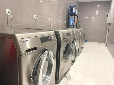a row of washing machines in a laundry room at NEW LUX 2BR Flat Free Parking Cedofeita Porto in Porto