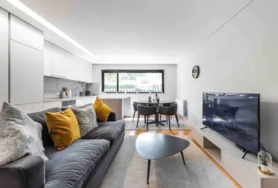 a living room with a couch and a tv and a kitchen at NEW LUX 2BR Flat Free Parking Cedofeita Porto in Porto