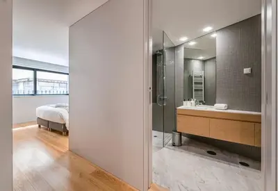 a bathroom with a shower and a sink and a bed at NEW LUX 2BR Flat Free Parking Cedofeita Porto in Porto