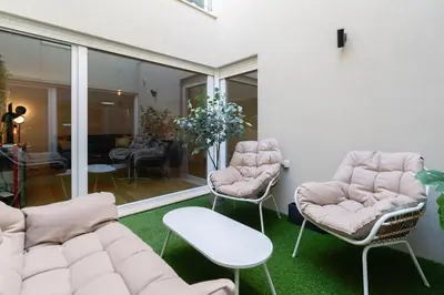 a room with two chairs and a couch and a table at Campanhã Duplex by Porto Stories in Porto