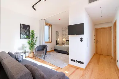 a living room with a couch and a bedroom at Prime Clerigos by Hosty in Porto