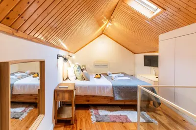 a bedroom with a large bed and a mirror at Vila Terra Studio Studio I in Vila Nova de Gaia