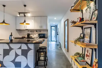 a kitchen with white cabinets and a counter with stools at Vila Terra Studio Studio I in Vila Nova de Gaia