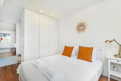 a white bedroom with orange pillows on a bed at Bombarda 250 by LovelyStay in Porto
