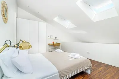 a white room with a bed and a lamp at Bombarda 250 by LovelyStay in Porto