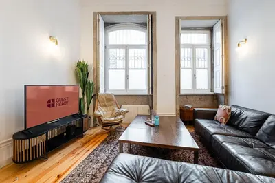 a living room with a leather couch and a coffee table at GuestReady - Mezzanine comfort in Porto in Porto