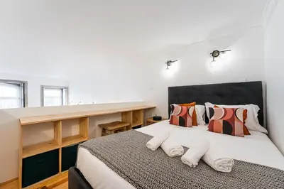 a bedroom with a large bed with pillows at GuestReady - Mezzanine comfort in Porto in Porto