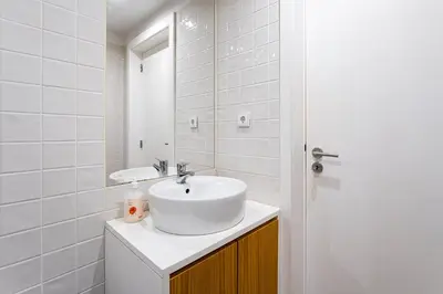 a white bathroom with a sink and a mirror at GuestReady - Mezzanine comfort in Porto in Porto