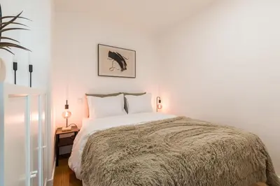 a white bedroom with a large bed with white pillows at Douro's Bridge View - Swimming pool in Vila Nova de Gaia