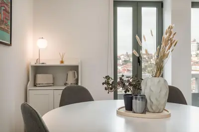 a white table with chairs and a vase on it at Douro's Bridge View - Swimming pool in Vila Nova de Gaia