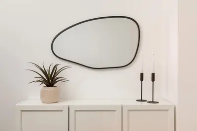 a dressing table with a mirror on a white wall at Douro's Bridge View - Swimming pool in Vila Nova de Gaia