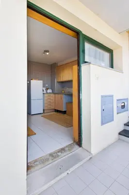 an open door into a kitchen with a refrigerator at Aposentus - Contemporary Comfort in Porto