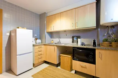 a kitchen with wooden cabinets and a white refrigerator at Aposentus - Contemporary Comfort in Porto