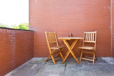 a table and two chairs sitting next to a brick wall at Aposentus - Contemporary Comfort in Porto