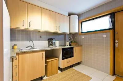 a kitchen with wooden cabinets and a sink and a microwave at Aposentus - Contemporary Comfort in Porto