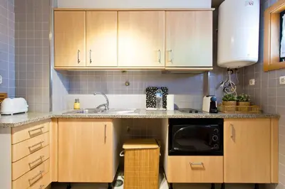a kitchen with wooden cabinets and a microwave at Aposentus - Contemporary Comfort in Porto
