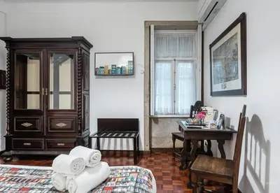 a bedroom with a bed and a desk and a table at Office Suits in Flores by D&S in Porto