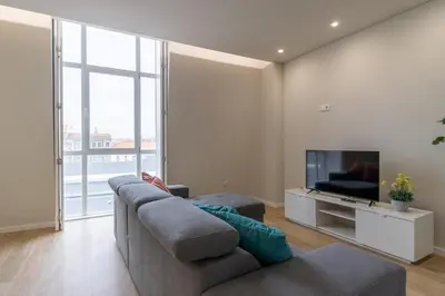 a living room with a couch and a tv at Bolhão Market Apartment in Porto