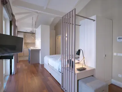 a bedroom with a bed and a desk with a television at New Oporto Apartments - Cardosas in Porto