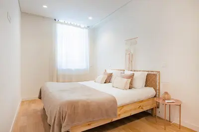 a kitchen with white cabinets and a white table at Paraíso City Stay I in Porto