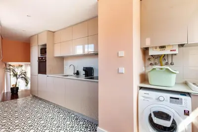 a kitchen with a washer and dryer in a room at Superb Apartment in the HEART of Historical Center in Porto