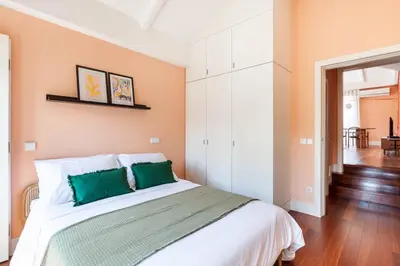 a bedroom with a large bed with green pillows at Superb Apartment in the HEART of Historical Center in Porto