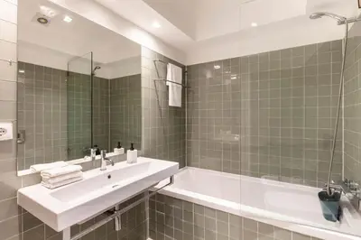 a bathroom with a sink and a tub and a mirror at Superb Apartment in the HEART of Historical Center in Porto