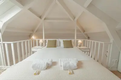 a bedroom with a large white bed in a attic at Downtown Elegant by Hosty in Porto